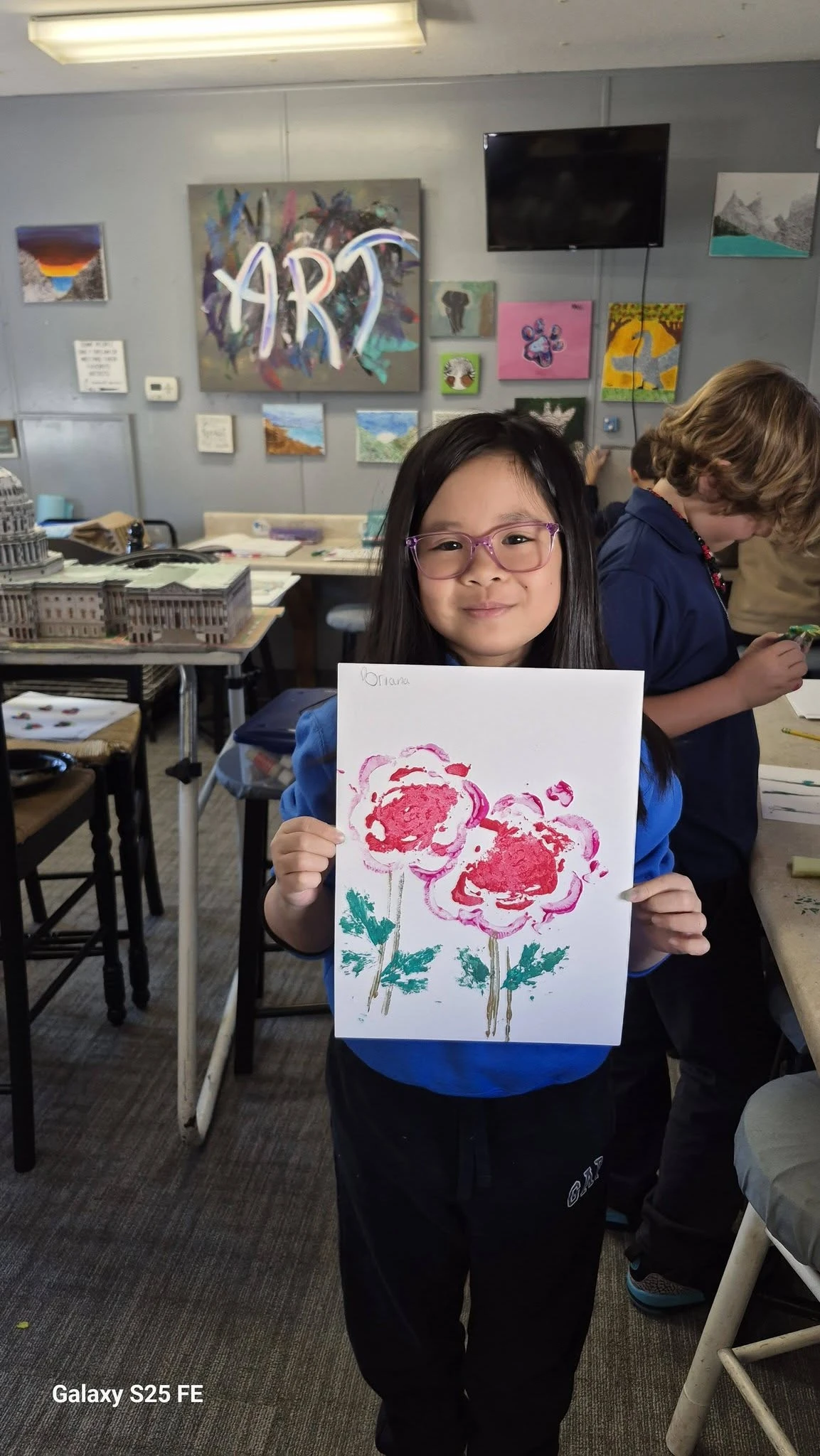 Genesis Elementary student displaying her flower painting